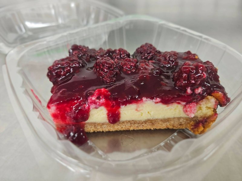 Slice of cheesecake topped with berry sauce