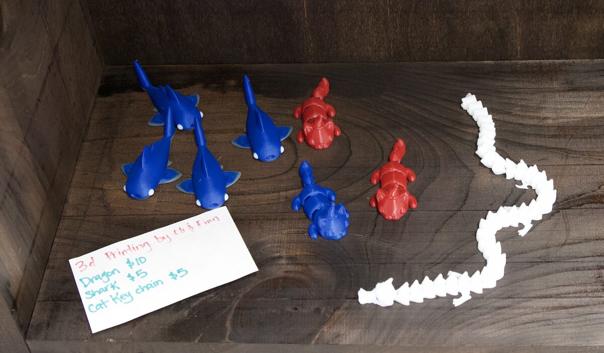 3D printed dragons, sharks and cat keychains in red, blue and white