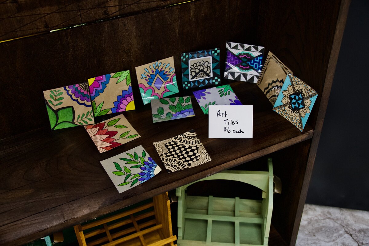 Hand-painted art tiles with floral and geometric designs, six dollars each
