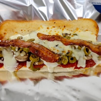 Sub topped with bacon, mushrooms and green olives