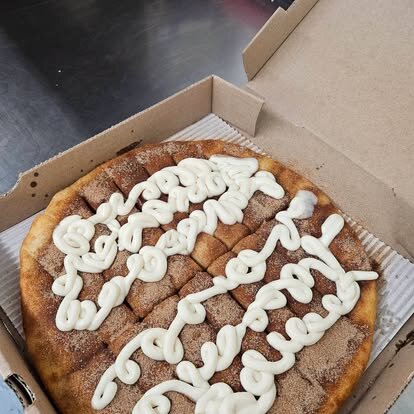 Cinnamon dessert pizza drizzled with cream cheese icing