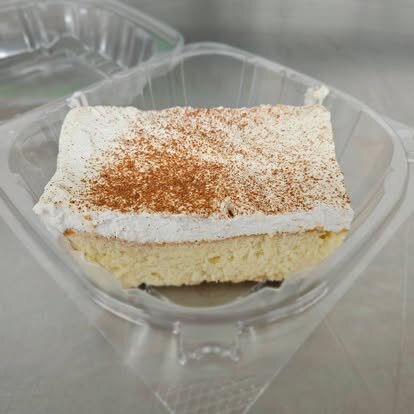 Tiramisu topped with whipped cream and cocoa powder